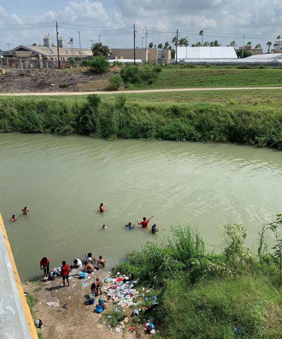 Women, children, and men bathing on the Mexican side of the Rio Grande, just across from Brownsville, Texas.