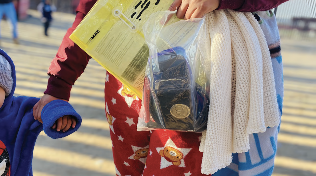 An individual holding a small bag of important belongings and documents.